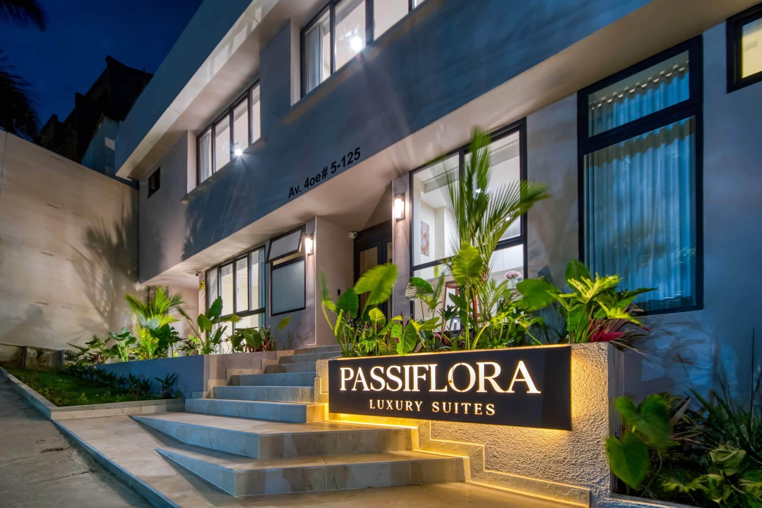 A modern building with a sign for 'Passiflora Luxury Suites' at the entrance.