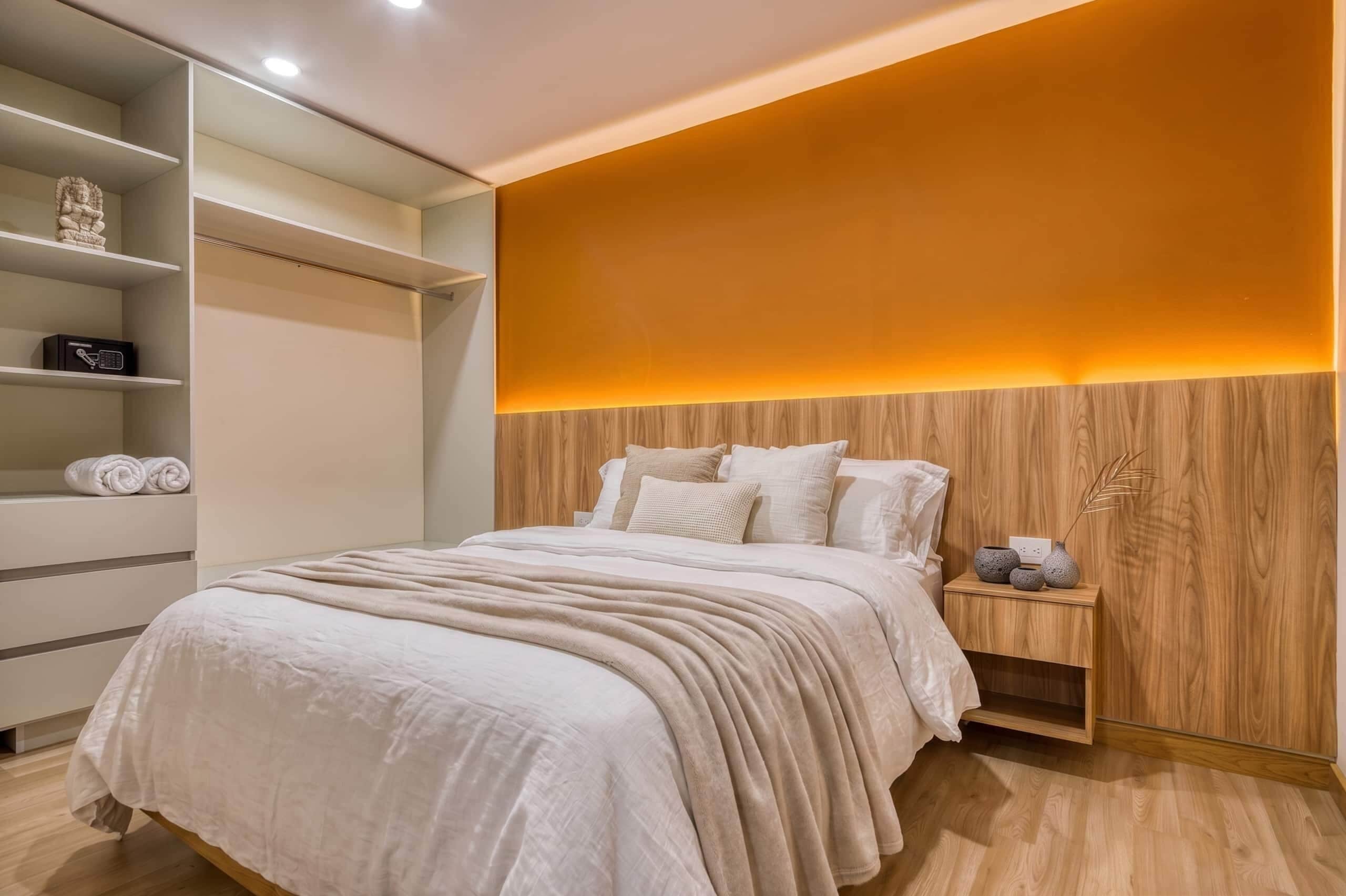 A bedroom with a bed, bedside table, and a wardrobe.