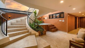 A modern interior with a spiral staircase, a hot tub, and a seating area. - Passiflora luxury suite (Cali)