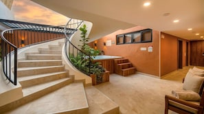 A modern interior with a spiral staircase, a hot tub, and a seating area. - Passiflora luxury suite (Cali)
