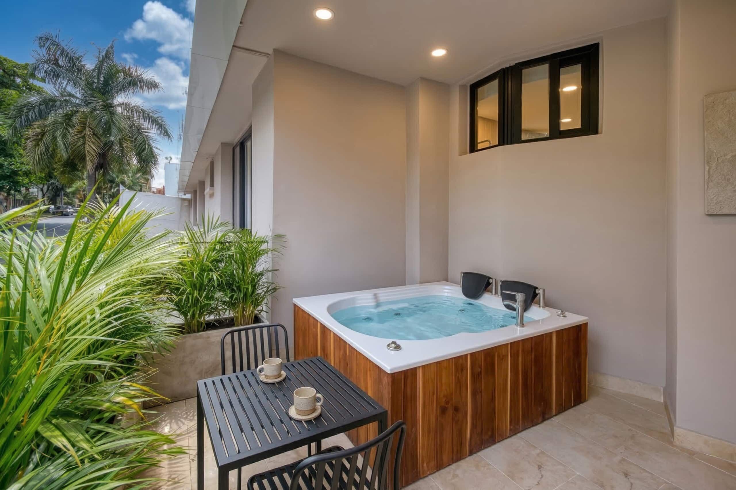Un jacuzzi con revestimiento de madera, una mesa con sillas y plantas en macetas.