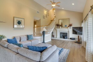 A living room with a beige sofa, a staircase, and a fireplace. - Amazing Mtn & City Views! Simi Valley Hideaway (Simi Valley)
