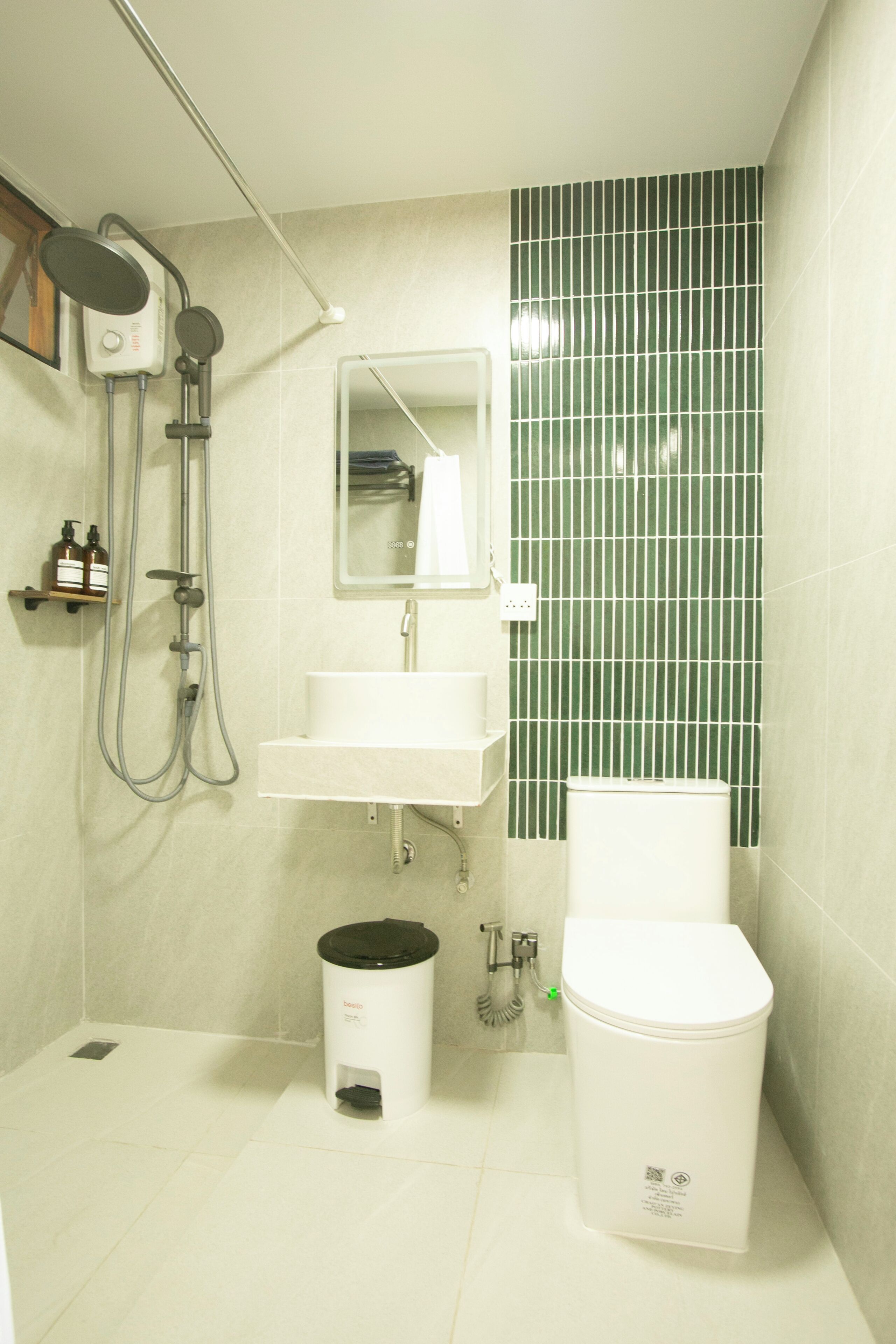 Un baño con ducha, lavamanos, espejo y retrete.