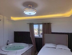 A room with a bed, a window with curtains, a radiator, and a ceiling light fixture. - Apt Aconchegante+Private Jacuzzi+Wi-Fi+AC in Santo Domingo RD (Santo Domingo)