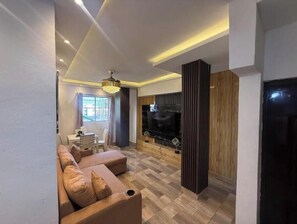 A modern living room with a sofa, a television, and a fireplace. - Apt Aconchegante+Private Jacuzzi+Wi-Fi+AC in Santo Domingo RD (Santo Domingo)