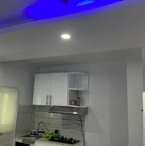 A kitchen with white cabinets, a stainless steel range hood, and a window with a blind. - Apartment with roof + jacuzzi + Wi-Fi + AC in Santo Domingo RD (Santo Domingo)