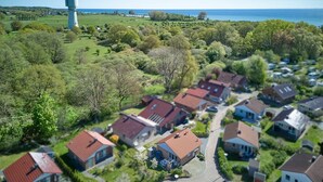 A residential area with houses, a lighthouse, and a view of the sea.