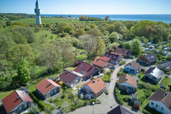 Un quartier résidentiel avec des maisons, un phare et une vue sur la mer.