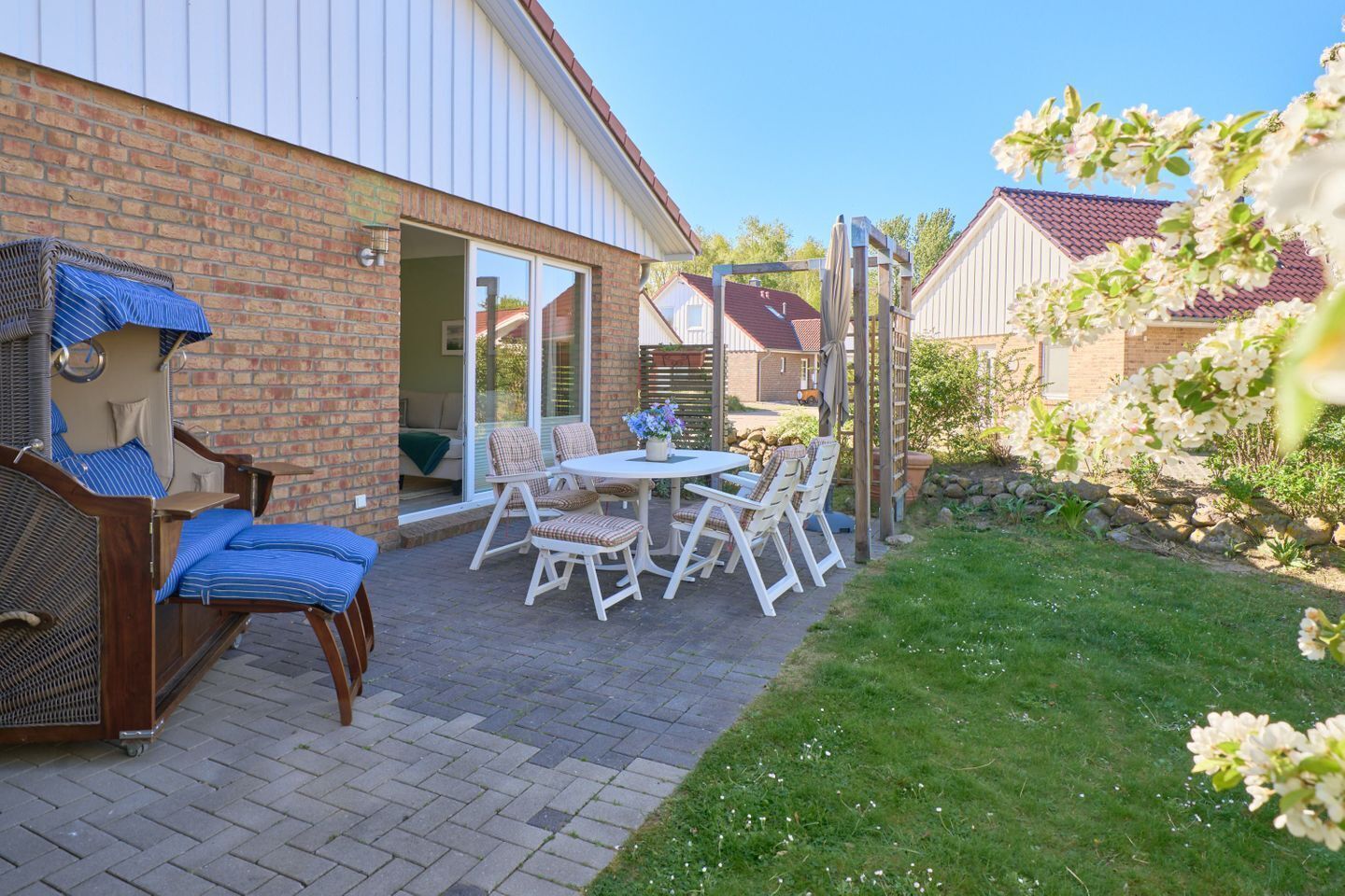 A patio with a table and chairs, a covered seating area, and a brick wall.