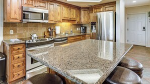 A kitchen with wooden cabinets, stainless steel appliances, a granite countertop, and a skylight. - Golf, Boat, Swim! Walkable Lake Havasu Getaway (Lake Havasu City)