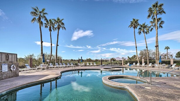 A clear pool with lounge chairs and palm trees. - Golf, Boat, Swim! Walkable Lake Havasu Getaway (Lake Havasu City)