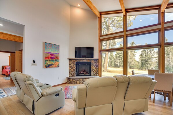 A living room with a fireplace, a television, and large windows. - 2 Mi to Angel Fire Resort: Year-Round Retreat (Angel Fire)