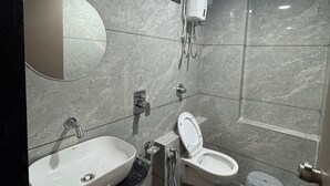 A modern bathroom with a sink, toilet, and shower.