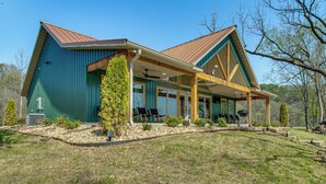 A two-story house with a covered porch, a large window, and a small tree in front. - 'CopperTop Cabin' Waterfront White River Retreat (Norfork)