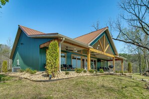 A two-story house with a covered porch, a large window, and a small tree in front. - 'CopperTop Cabin' Waterfront White River Retreat (Norfork)
