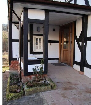 Un edificio tradicional con entramado de madera, una puerta de madera y una ventana pequeña.