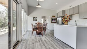A modern kitchen with a dining area, large windows, and a view of the outdoors. - Mtn & Creek Views! Harrisonburg Escape on 10 Acres (Harrisonburg)