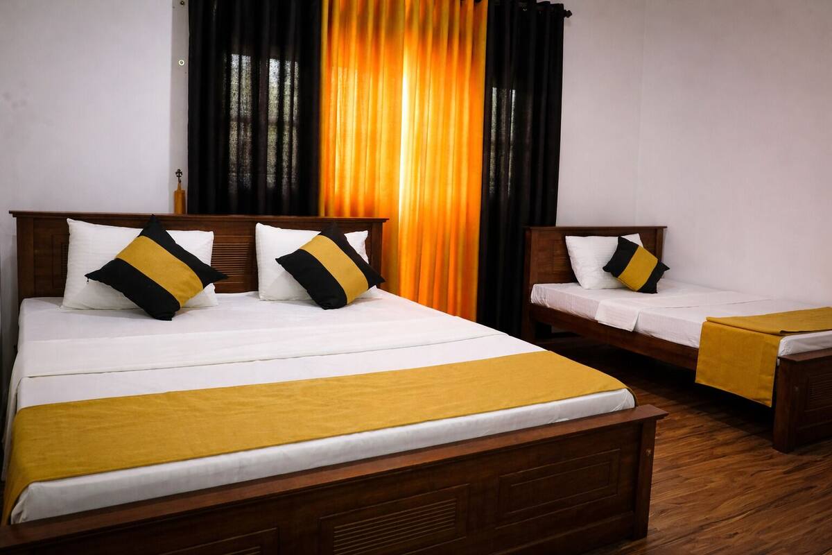 Dos camas dobles con cabeceros de madera, ropa de cama blanca y detalles en amarillo.