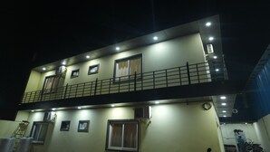 Un edificio de varios pisos con balcones, unidades de aire acondicionado y una escalera.