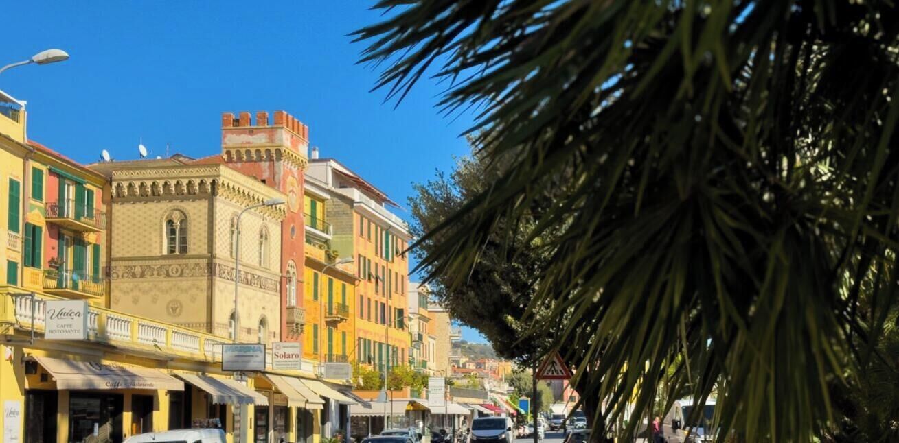 A street lined with colorful buildings, a café, and a restaurant.