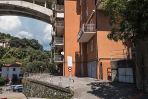 Ein mehrstöckiges Gebäude mit Balkonen, einem Stoppschild und einem Verbotsschild für parkende Fahrzeuge.