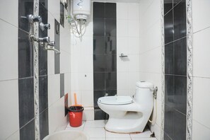 A bathroom with a toilet, a bidet, a red trash bin, and a white sink. - Hotel The Nayee Haveli - Lake View Hotel (Udaipur)