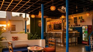 An indoor dining area with a bar, seating arrangements, and a menu board.