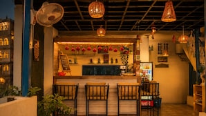 A bar area with a counter, seating, and decorative elements like hanging lights and wall decorations.