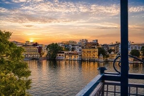 Vista de la ciudad a la orilla del río, con edificios históricos y un atardecer.