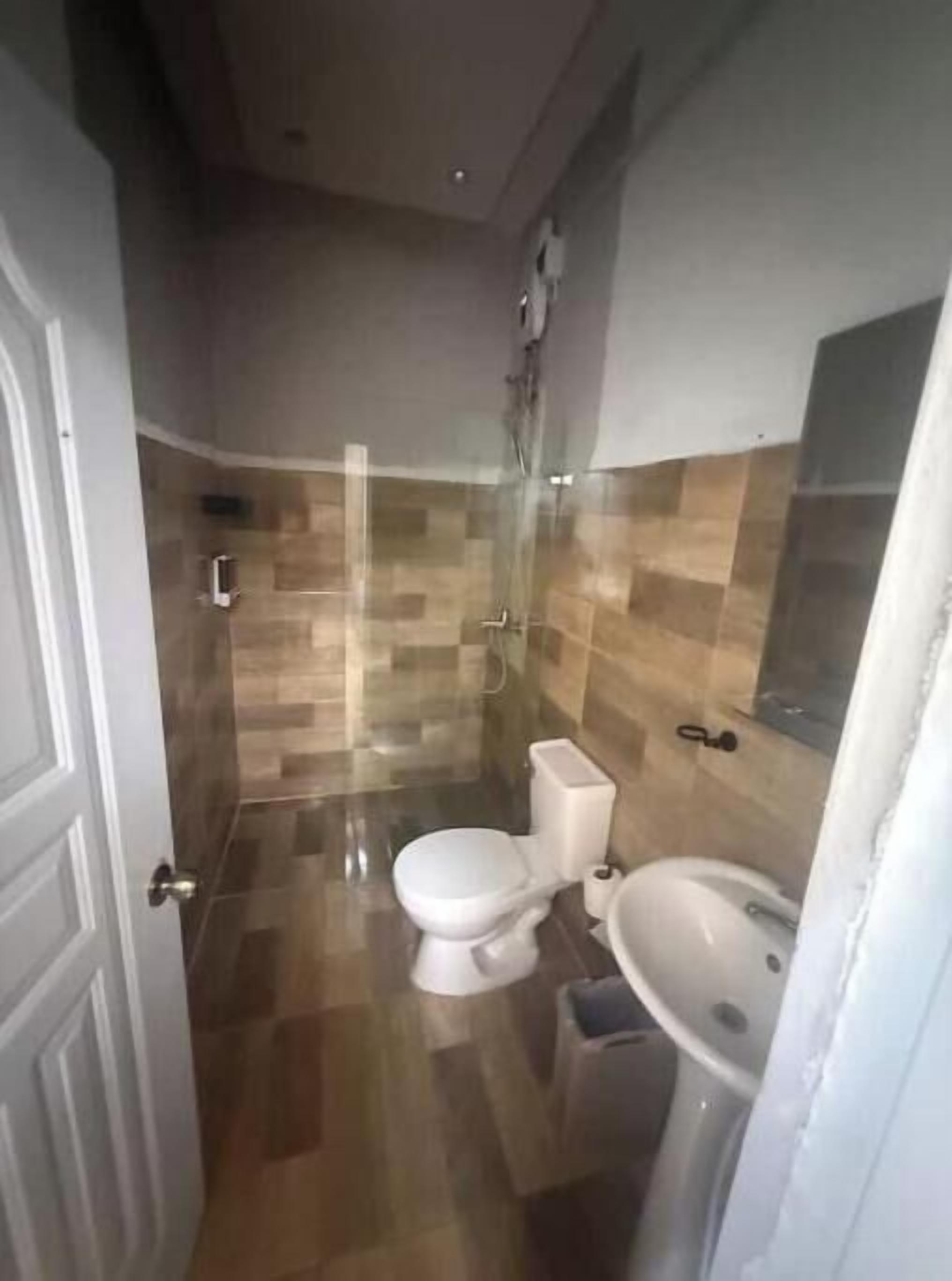 Een badkamer met toilet, wastafel en douche.