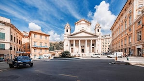 A street view with a classical building featuring columns and a central dome, surrounded by urban buildings. - GALIA ROOMS (Genoa)