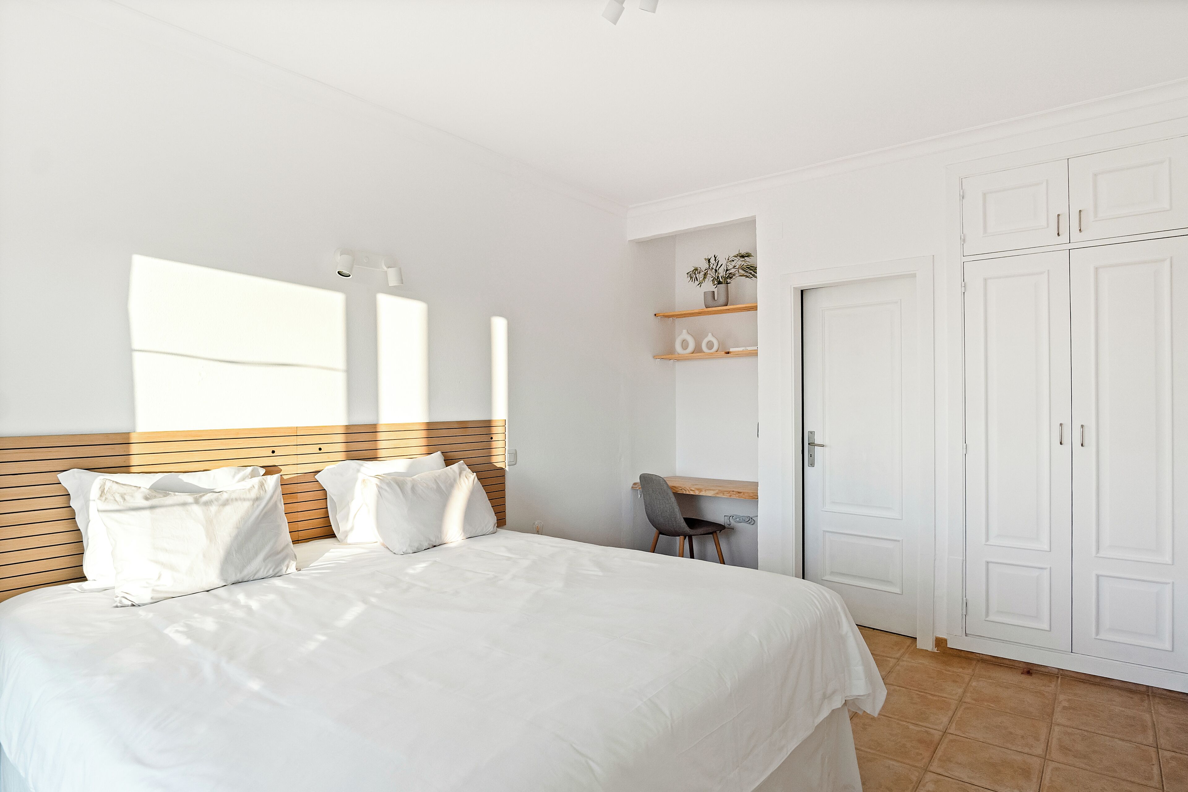 Une chambre à coucher avec un lit, un bureau et une armoire.