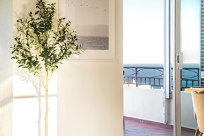 A room with a potted plant, a framed picture of a landscape, and a view of a balcony with a railing. - Villa with stunning Ocean Views & Priv. Heated Pool (Luz)