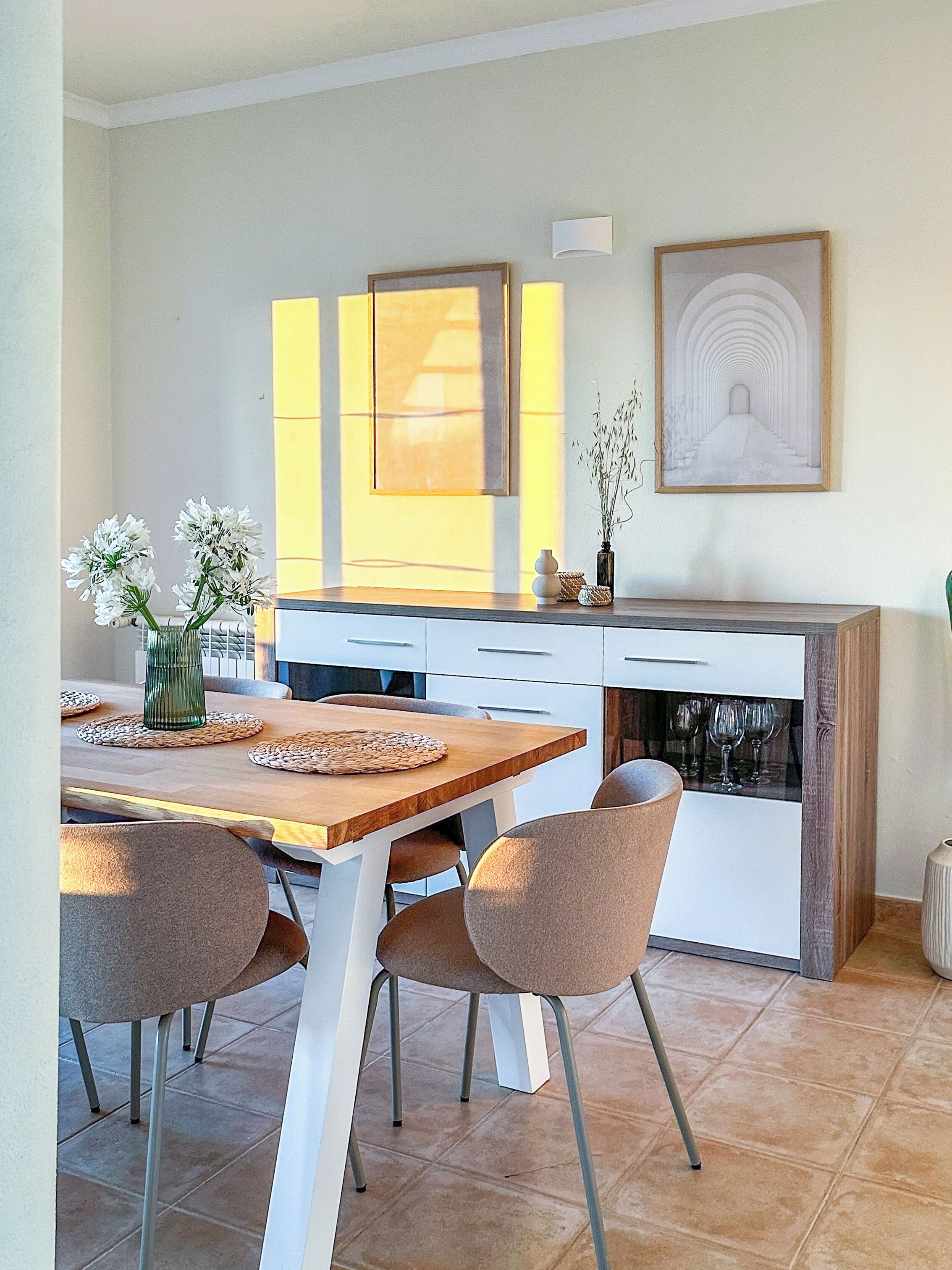 A modern kitchen with a dining table, chairs, and a fireplace.
