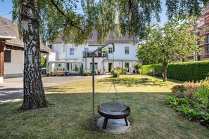 A residential property with a well-maintained lawn, a swing set, and a house with a tiled roof.