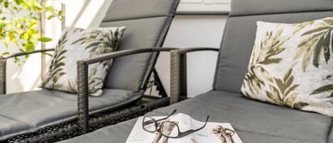 Un canapé avec un magazine et des lunettes dessus.