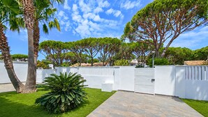 A courtyard with a paved walkway, white walls, and green grass. - 4 bedroom lovely home in Roche (Roche)