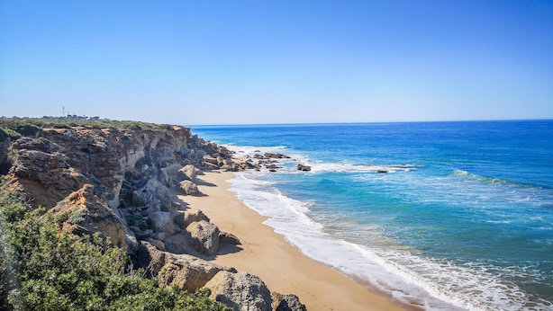 A coastal landscape with a sandy beach, rocky cliffs, and a clear blue sky. - 4 bedroom lovely home in Roche (Roche)