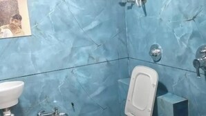 Ein Badezimmer mit Toilette, Waschbecken und einem an der Wand befestigten Händetrockner.