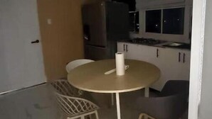 A compact kitchen with a dining table, chairs, and a refrigerator. - Paradise paradise oasis private jacuzzi (Santo Domingo)