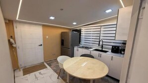 A compact kitchen with a dining table, a refrigerator, and a stove. - Paradise paradise oasis private jacuzzi (Santo Domingo)