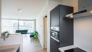 Een koffiezetapparaat/waterkoker, een koelkast, een oven, een kookplaat