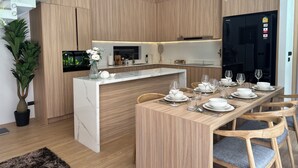 Eine moderne Küche mit Holzschränken, einer Marmorarbeitsplatte und einem Essbereich, gedeckt für sechs Personen.