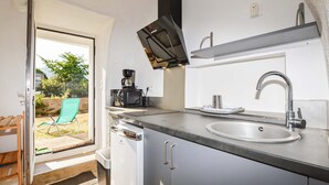 A compact kitchen with a built-in microwave, a sink, and a coffee maker. - 1 bedroom amazing apartment in Moriani-Plage (Moriani-Plage)