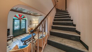 Een trap die leidt naar een kamer met een bed, een stoel en een tafel.