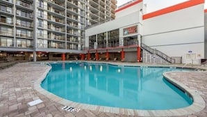 Un albergo con piscina, un edificio a più piani e un cartello che indica un ristorante.