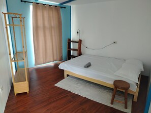 A bedroom with a wooden bed, a wooden ladder, a window with curtains, and a wall socket. - Blu Corner - a place to relax (Lian)