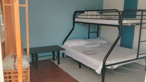 A bunk bed room with a wooden ladder, a small table, and a rug on the floor. - Blu Corner - a place to relax (Lian)