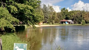 A calm lake with a dog park sign, surrounded by trees and a small building. - Family Cottage Retreat in Marminiac (Marminiac)