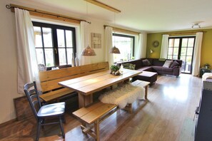 Un coin repas comprenant un banc en bois, une table et une chaise.